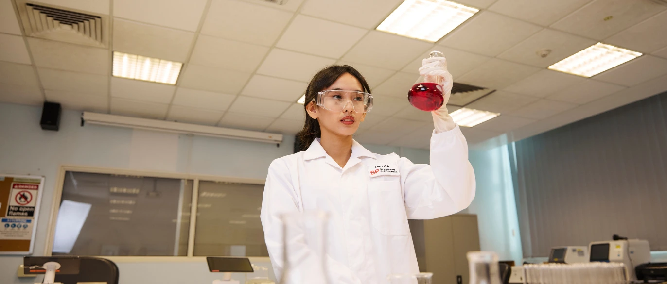 student looking at test tube