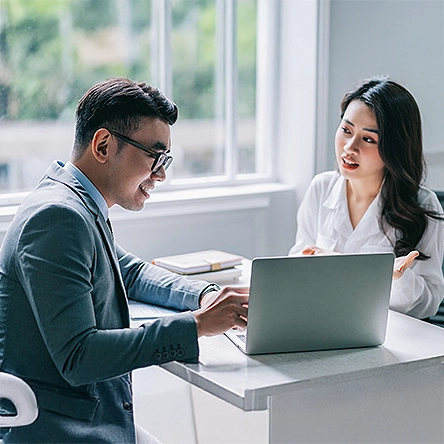Man and woman discussing over a laptop.