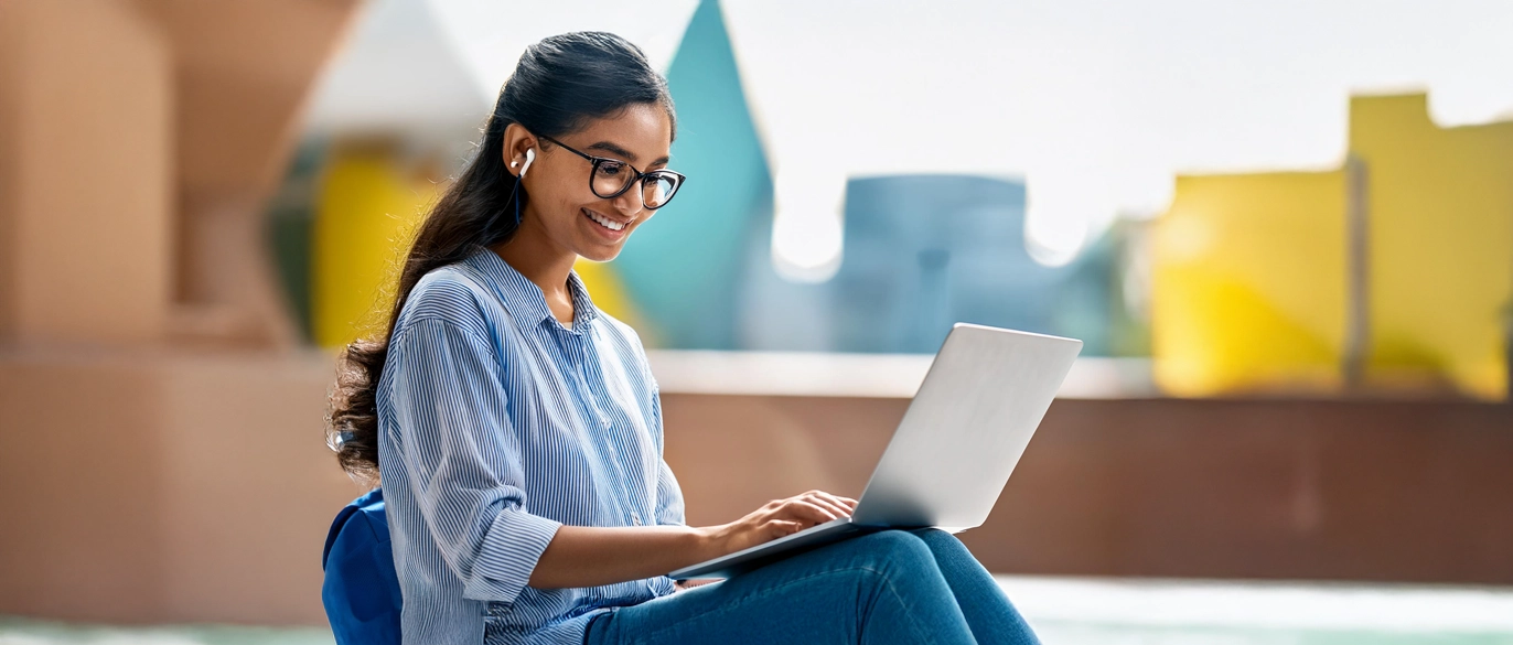 Image of a student using her laptop to access online e-services.